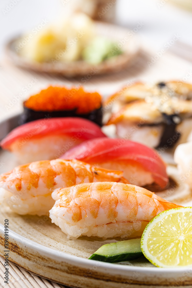 Set of sushi and maki on plate with soy sauce and chopsticks on white background. Top view with copy space Set of sushi and maki on plate with soy sauce and chopsticks on white background. Top view with copy space