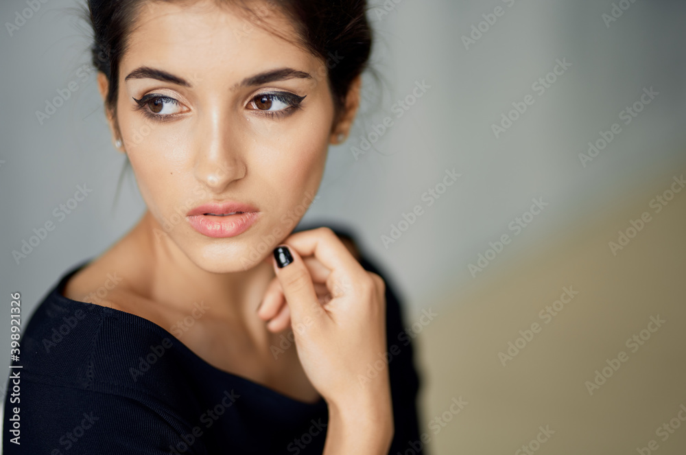 elegant woman in dark dress indoors holds hand near face portrait close-up elegant woman in dark dress indoors holds hand near face portrait close-up