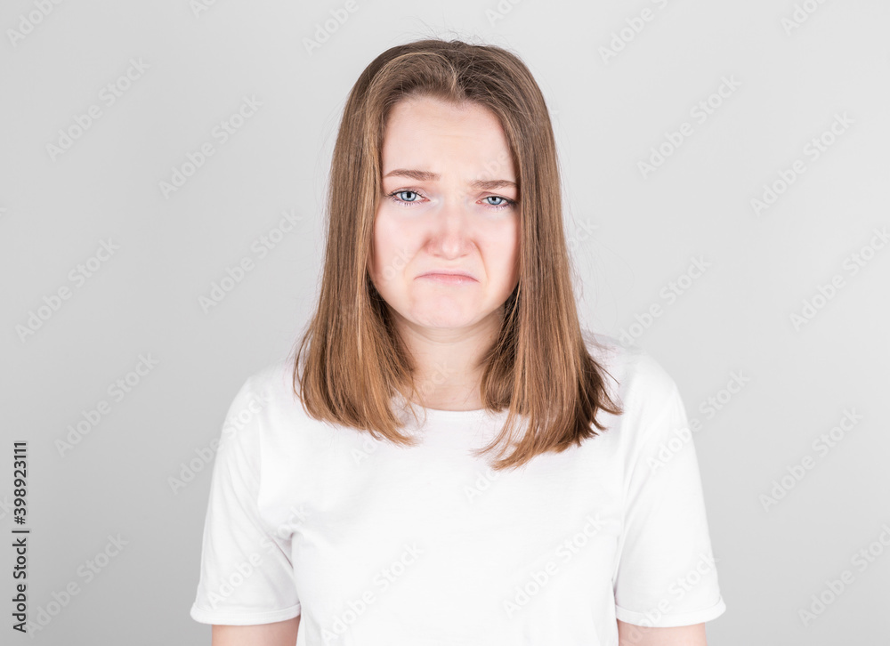 Portrait of displeased upset female frowns face as going to cry, isolated over gray studio background. Dissapointed young woman has troubles Portrait of displeased upset female frowns face as going to cry, isolated over gray studio background. Dissapointed young woman has troubles