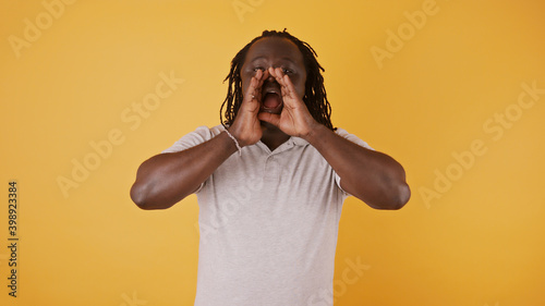 Black man with hands over his mouth announcing something. High quality photo