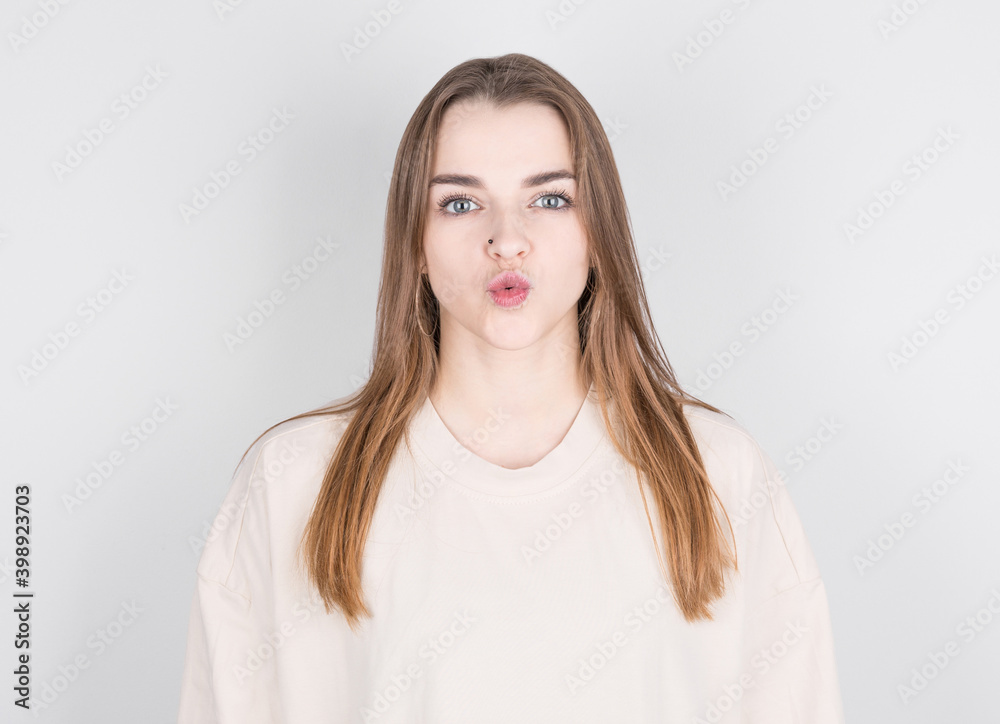 Portrait of lovely girl in casual outfit sending blowing kiss with pout lips looking at camera isolated on white background. Portrait of lovely girl in casual outfit sending blowing kiss with pout lips looking at camera isolated on white background.