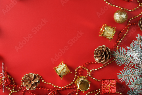 Christmas arrangement of Christmas ornaments and Christmas tree decorations on a red background.
