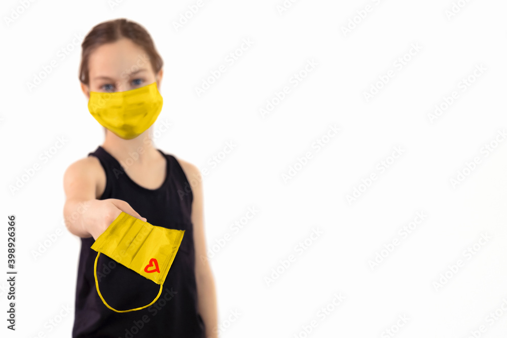 Teenage girl in a protective mask gives a new mask and offers to dress it. Teenage girl in a protective mask gives a new mask and offers to dress it.