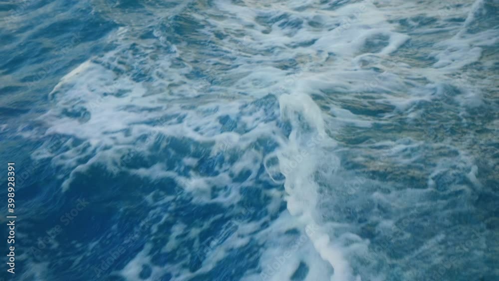 Water foam trace behind the ship. Blue sea water with boat trace. Slow motion.
Water foam trace behind the ship. Blue sea water with boat trace. Slow motion.
