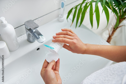 Close up of woman's hands applying micellar water to cotton pad photo