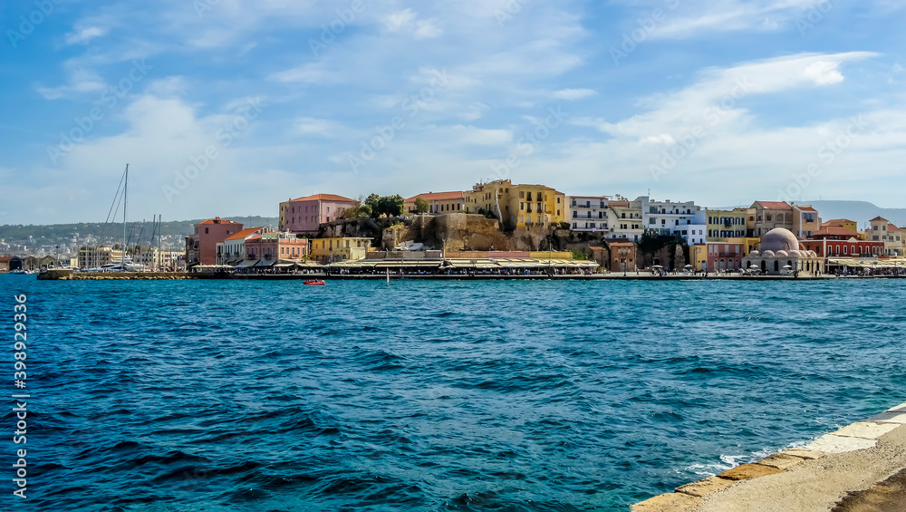 A view across the entrance to the main harbour and marina in Chania, Crete on a bright sunny day