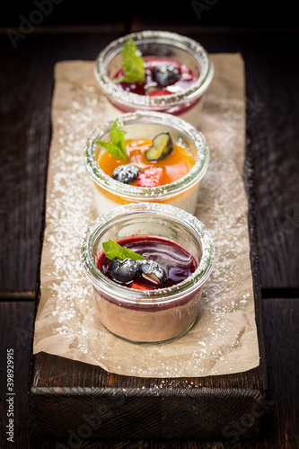 assorted panna cotta with jam decorated with fruit