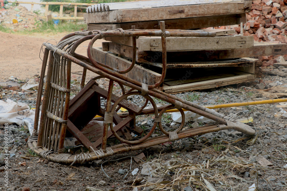 broken and dirty Cane bamboo swing chair on ground