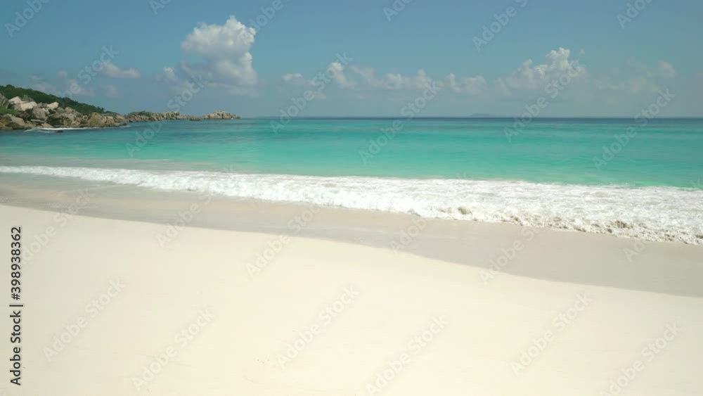 Exotic beach by the ocean with rolling waves on the sandy shore and blue sky. Exotic beach by the ocean with rolling waves on the sandy shore and blue sky.