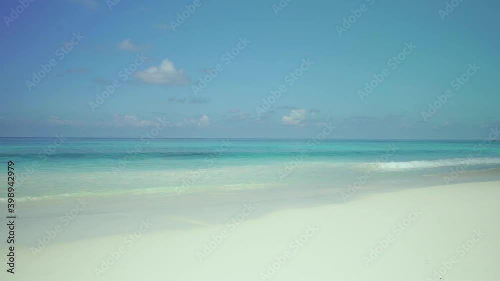 Exotic beach by the ocean with rolling waves on the sandy shore and blue sky. Exotic beach by the ocean with rolling waves on the sandy shore and blue sky.