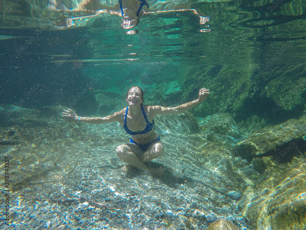 girl swims in the crystal clear green water