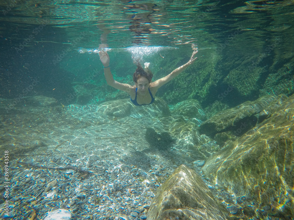 girl swims in the crystal clear green water