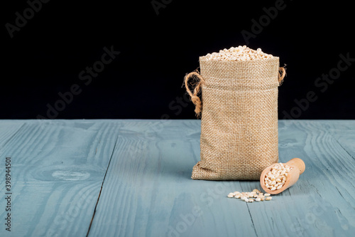 Retro style wooden background. There is a small bag on it, it is barley. Place for your text. Copy space. photo