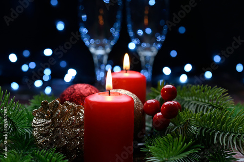 Lighted red candles surrounded by holiday decorations.
