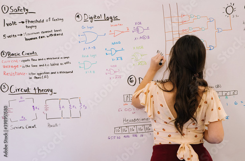 Student working on a whiteboard learning engineering and electronics STEM education