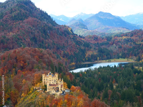 Panoramablick über das Gebiet von Schwangau mit Schloss Hohenschwangau umgeben von bunten Herbstwäldern und vor der Kulisse der bayerischen Alpen. photo