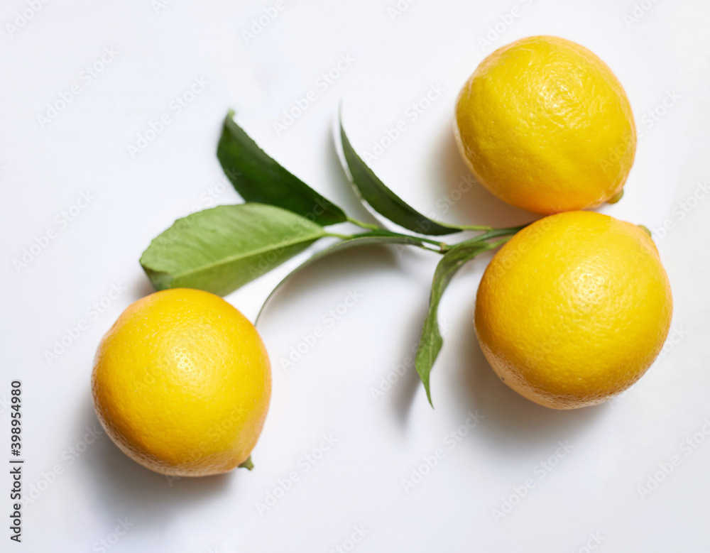 ripe yellow lemon with a branch on a white background