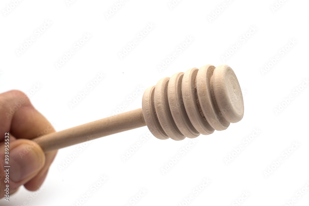 Closeup of wooden honey spoon in hand on white background Closeup of wooden honey spoon in hand on white background