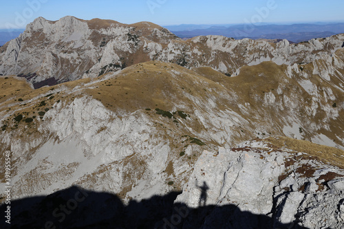 Shadow of man waving on top of mountain 