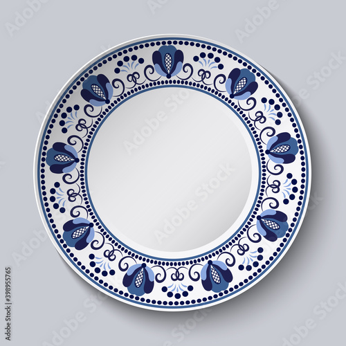 Porcelain plate with a blue decorative border in the style of national flower painting. Ornate floral decor. Realistic 3D decor.