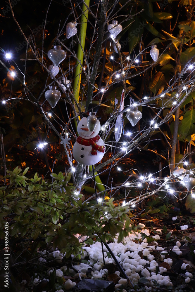 Arbre illuminé d'une guirlande lumineuse et décoré pour Noël dans la nuit