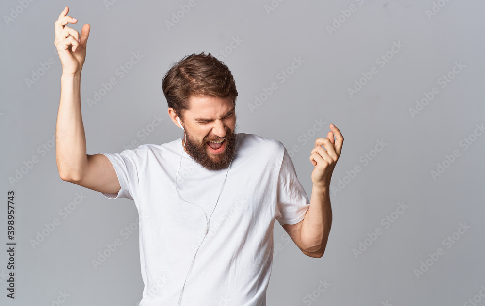 energetic man in headphones dancing on gray background and listening to music cropped view energetic man in headphones dancing on gray background and listening to music cropped view