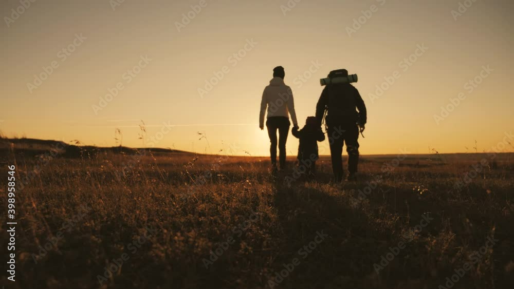Silhouettes of father, mother and little son. Hiking backpackers trekking mountains summer. Young family on travel adventure vacation. Silhouettes of father, mother and little son. Hiking backpackers trekking mountains summer. Young family on travel adventure vacation.