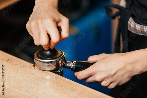 Barista prepares coffee and presses ground coffee for the machine. Close-up of the hands. High quality photo