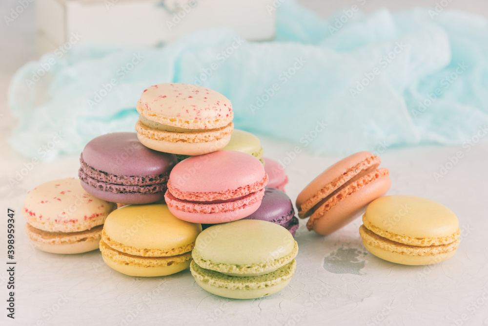 Stacked pastel colored french macarons in front of a white wall Stacked pastel colored french macarons in front of a white wall