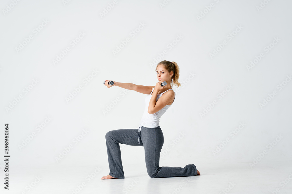 athletic woman sitting on one knee and holding dumbbells in hand fitness sport model athletic woman sitting on one knee and holding dumbbells in hand fitness sport model