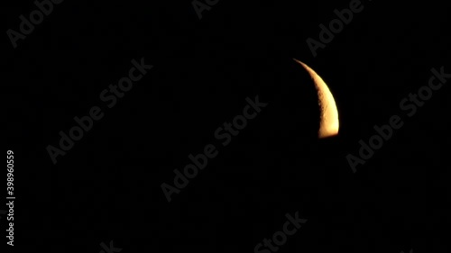 the moon hides behind the roof of the house