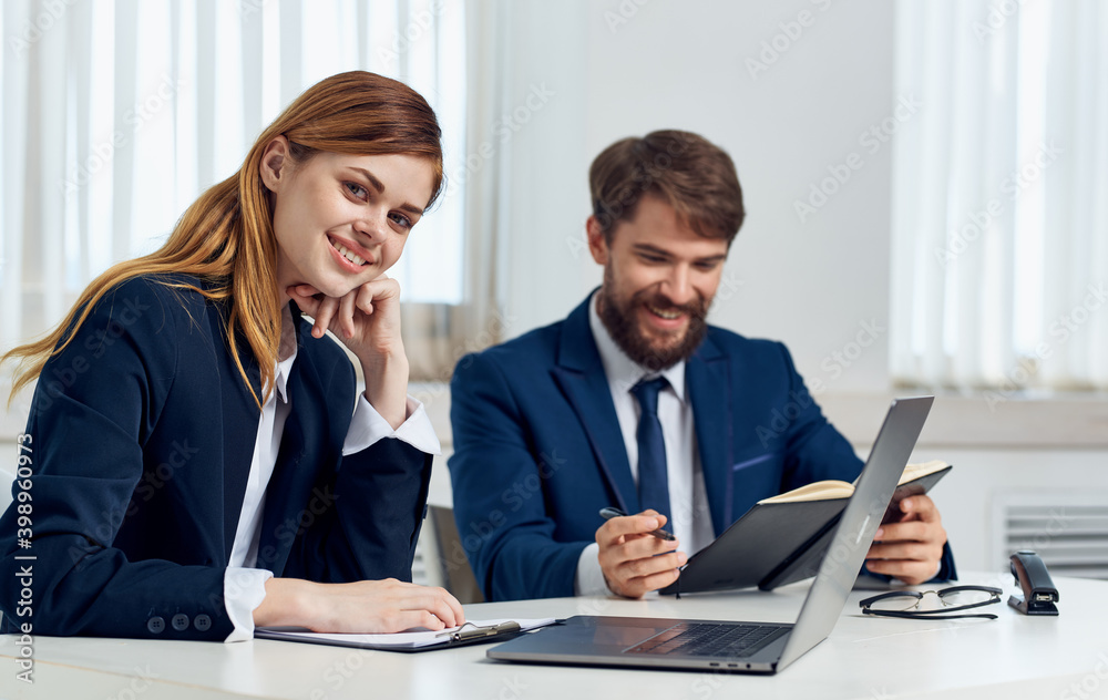 Happy Business people in the office with a laptop are sitting at the table In a bright room Happy Business people in the office with a laptop are sitting at the table In a bright room