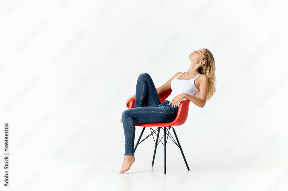 women in a red armchair in a bright room portrait interior model women in a red armchair in a bright room portrait interior model