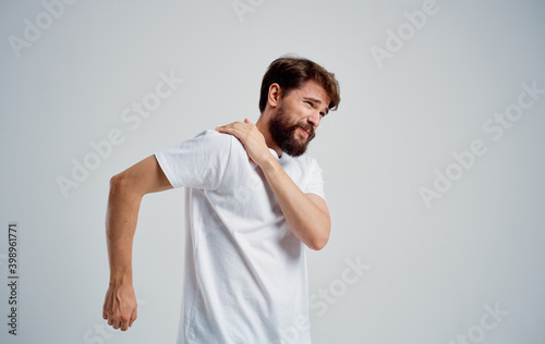 man has shoulder pain and white t-shirt dislocation health problems