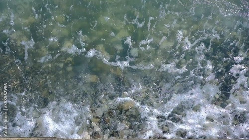 the waves slowly roll over the pebble beach
