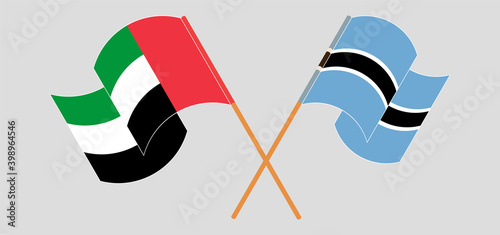 Crossed and waving flags of the United Arab Emirates and Botswana