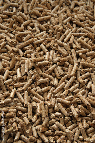 Wood pellets texture. Granules made from compressed wood and used as natural cat litter. Eco-friendly and biodegradable material. Vertical image. photo