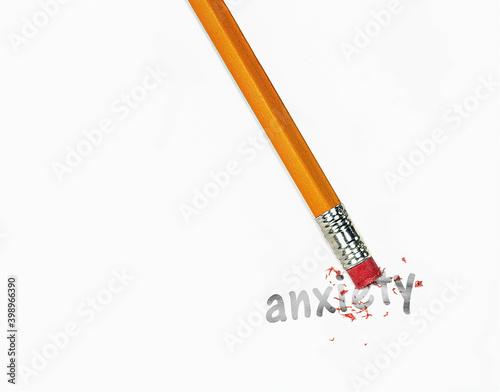 Photography close up of wooden yellow pencil erasing anxiety text on white paper