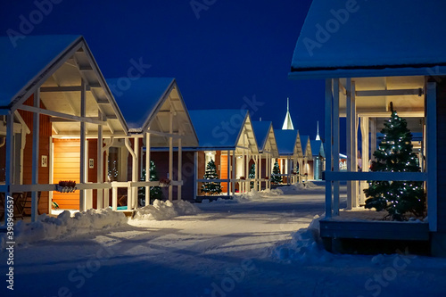 Φωτογραφία Illuminated cabins with Christmas trees in the arctic snow
