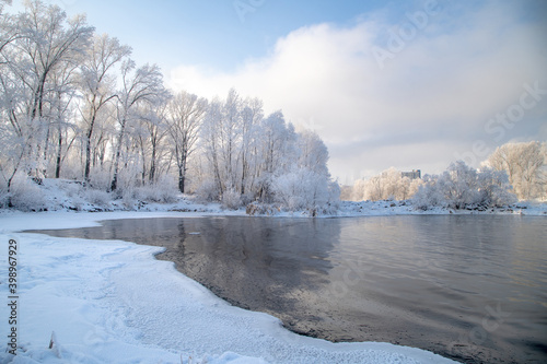 Winter day on the river, partially covered with ice. On the shore there are trees in hoarfrost. © Тамара Андреева
