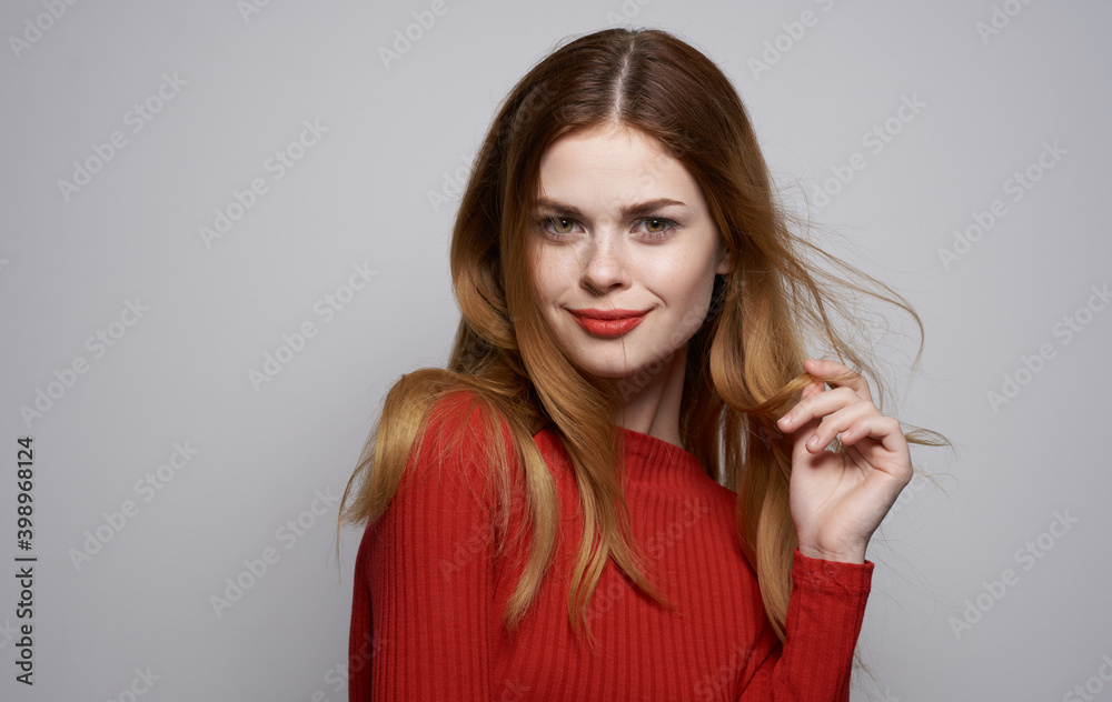 Beautiful woman in red sweater bright makeup gray background cropped view Beautiful woman in red sweater bright makeup gray background cropped view
