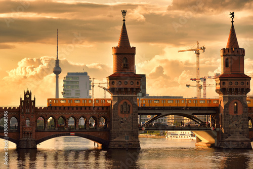 Old bridge with a train across the river against sunset sky in Berlin, Germany