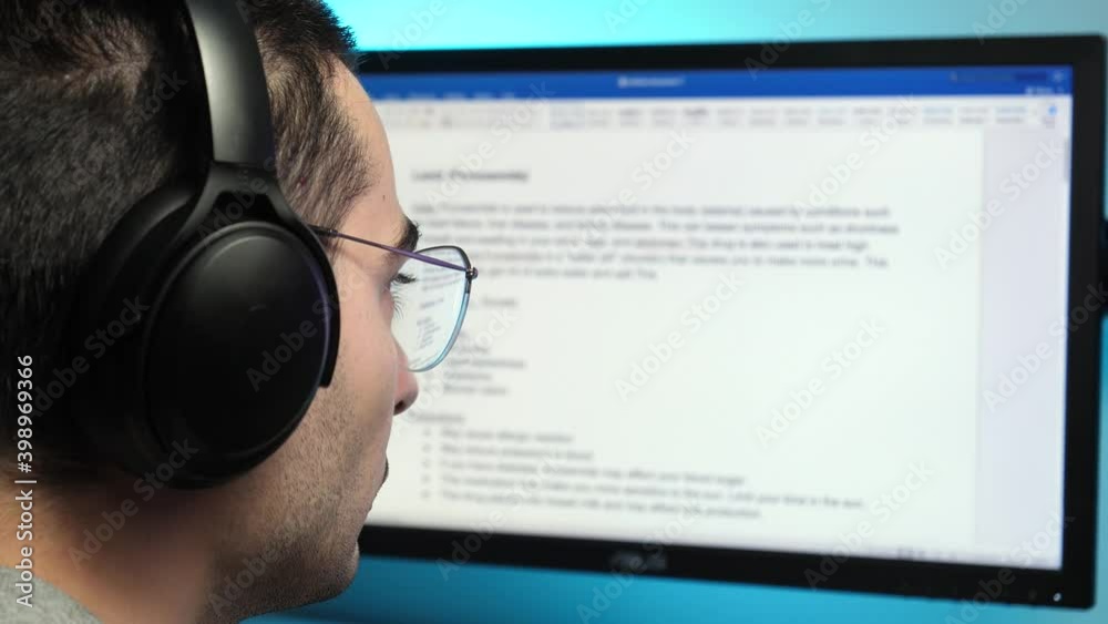 Writing a text in a text editor on a computer monitor wearing headphones at home. freelancer, student concept shot.