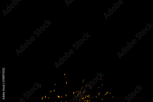 Burning red hot sparks fly from large fire in the night sky. Beautiful abstract background on the theme of fire, light and life.