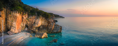 Fototapeta Naklejka Na Ścianę i Meble -  Beautiful Milopotamos beach at Pelion Greece, with arch on sunrise time, wide panorama