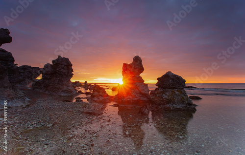 Typical limestone rocks from Gotland. They are called rauks or rauk-fields. Sunrise over the Baltic Sea. photo