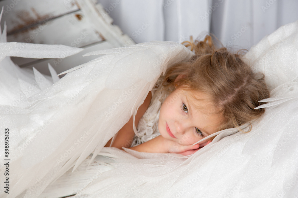 Christmas shooting of a cute little girl in the studio with wings Christmas shooting of a cute little girl in the studio with wings