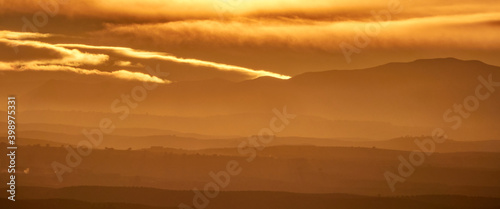 Nice autumn sunset with a cloudy sky over the silhouetted hills