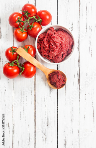 Fotografie, Obraz Traditional turkish tomato paste in bowl or spoon with fresh tomatoes on wooden