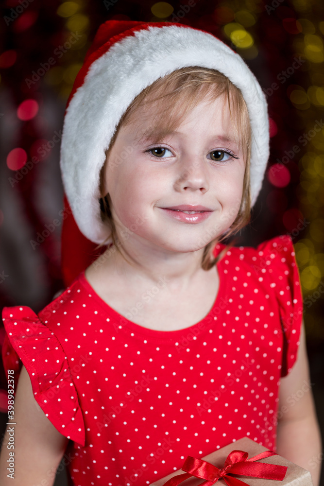 Cute Little Girl In Santa Hat is smiling at the camera. Cute Little Girl In Santa Hat is smiling at the camera.